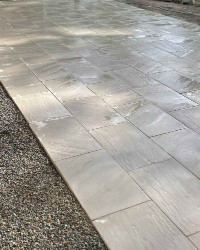 Large pale pavers laid in a strip beside a gravel bed