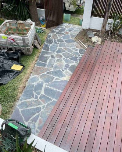 Crazy-pave stone path beside a timber deck, with a pallet of stone
